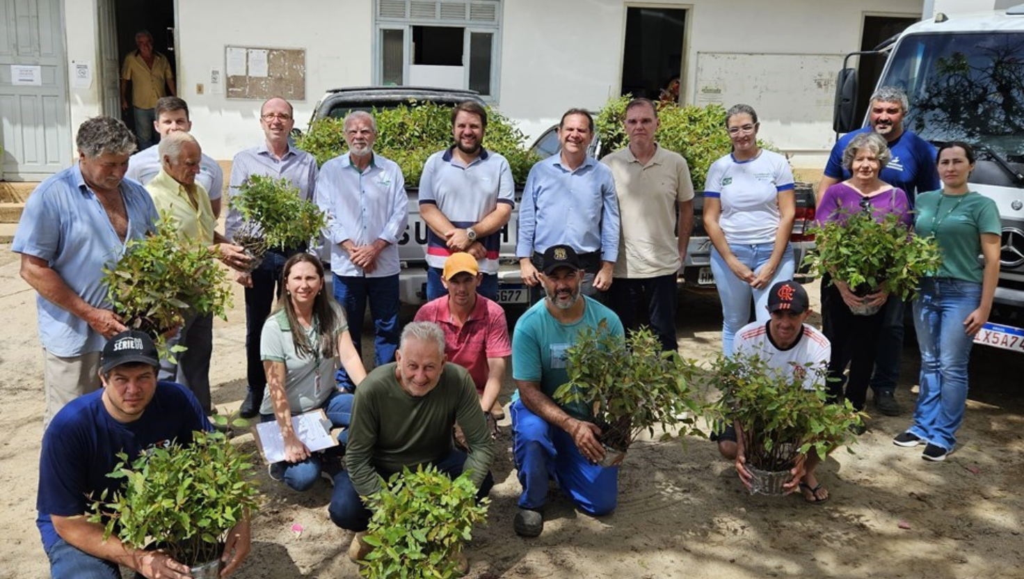 Imagem de agricultores recebendo mudas de eucalipto em Santa Teresa, com representantes do Incaper e autoridades municipais presentes.